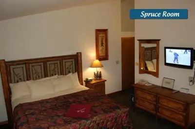 a hotel room with a bed and a tv at Wildwood Inn in Estes Park