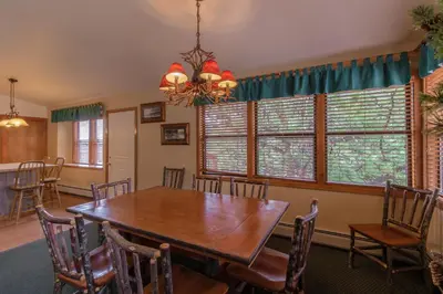 a dining room with a wooden table and chairs at Wildwood Inn in Estes Park