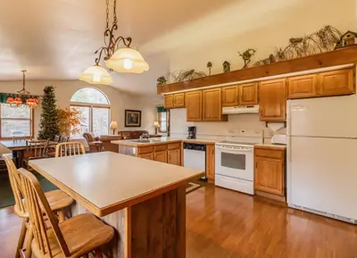 an open kitchen with wooden cabinets and a white refrigerator at Wildwood Inn in Estes Park