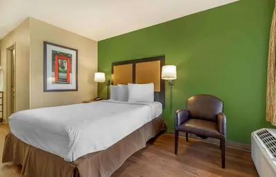a bedroom with a large bed and a chair at Extended Stay America Suites - Denver - Tech Center South - Inverness in Centennial