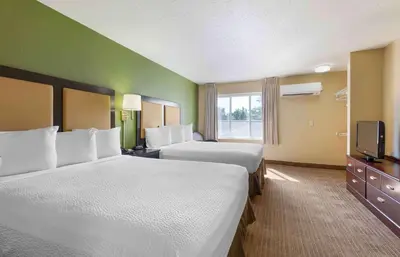 a hotel room with two beds and a television at Extended Stay America Suites - Denver - Tech Center South - Inverness in Centennial