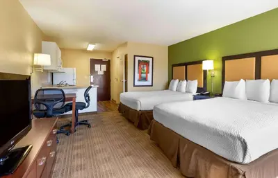 a hotel room with two beds and a desk at Extended Stay America Suites - Denver - Tech Center South - Inverness in Centennial