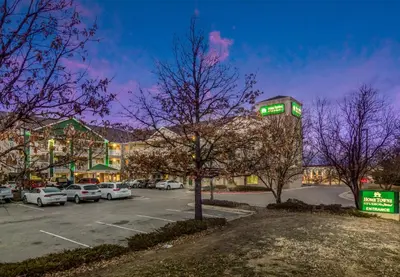 a parking lot with a building with a clock tower at HomeTowne Studios by Red Roof Denver - Airport/Aurora in Aurora