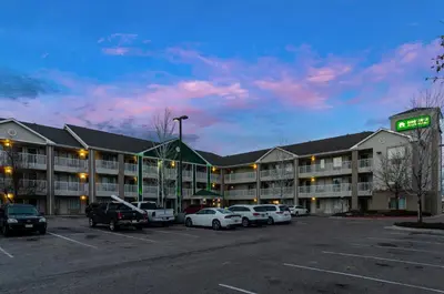 a hotel with cars parked in a parking lot at HomeTowne Studios by Red Roof Denver - Airport/Aurora in Aurora