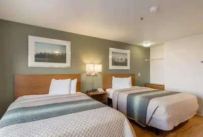 a hotel room with two beds and two lamps at HomeTowne Studios by Red Roof Denver - Airport/Aurora in Aurora