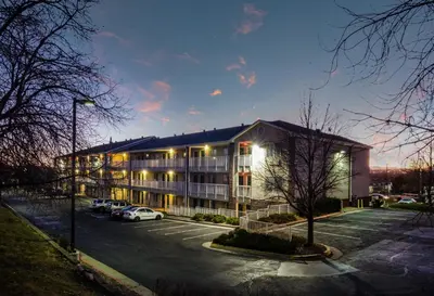 a large building with cars parked in a parking lot at HomeTowne Studios by Red Roof Denver - Thornton in Thornton