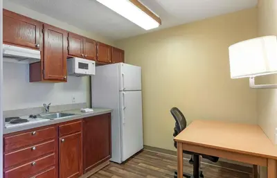 a small kitchen with a table and a white refrigerator at Extended Stay America Suites - Denver - Aurora North in Aurora