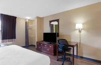 a hotel room with a bed and a desk with a television at Extended Stay America Suites - Denver - Aurora North in Aurora