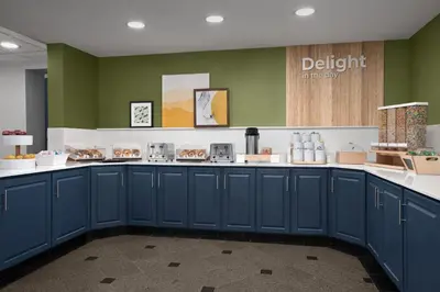 a kitchen with blue cabinets and green walls at Spark by Hilton Denver East I 70 in Denver