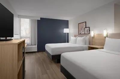 a hotel room with two beds and a flat screen tv at Spark by Hilton Denver East I 70 in Denver
