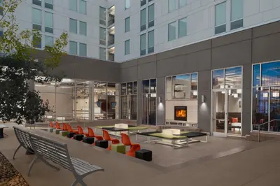 a building with chairs and tables and a fireplace at Aloft Broomfield Denver in Broomfield
