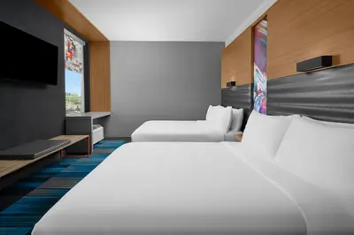 a hotel room with two beds and a flat screen tv at Aloft Broomfield Denver in Broomfield