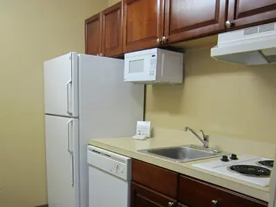 a kitchen with a white refrigerator and a sink at Extended Stay America Select Suites - Denver - Tech Center - Central in Greenwood Village