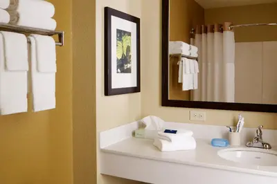 a bathroom with a sink and a mirror and towels at Extended Stay America Select Suites - Denver - Tech Center - Central in Greenwood Village