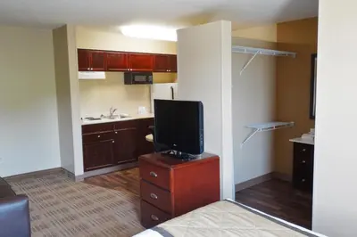 a room with a kitchen with a tv on a dresser at Extended Stay America Select Suites - Denver - Tech Center - Central in Greenwood Village