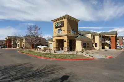 a hotel with a sign on the side of a road at Extended Stay America Select Suites - Denver - Tech Center - Central in Greenwood Village