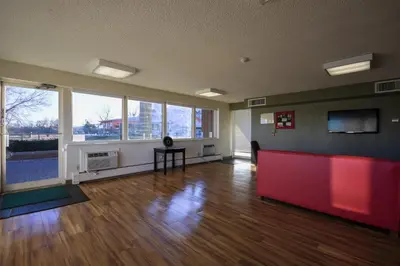 a large room with wooden floors and large windows at HomeTowne Studios by Red Roof Denver - Lakewood West in Lakewood