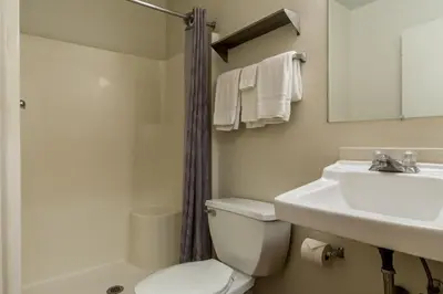 a bathroom with a toilet and a sink and a shower at HomeTowne Studios by Red Roof Denver - Lakewood West in Lakewood