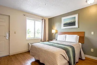 a bedroom with a bed and a window at HomeTowne Studios by Red Roof Denver - Lakewood West in Lakewood