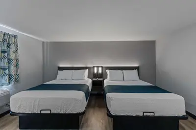 two beds in a small room with at Motel 6 Brighton CO Denver Northeast in Brighton