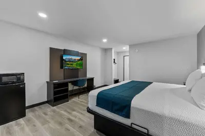 a bedroom with a bed and a desk and a television at Motel 6 Brighton CO Denver Northeast in Brighton
