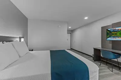a bedroom with a large bed and a desk at Motel 6 Brighton CO Denver Northeast in Brighton