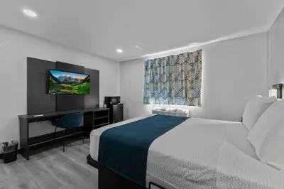a hotel room with a bed and a desk and a television at Motel 6 Brighton CO Denver Northeast in Brighton