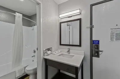 a bathroom with a sink and a toilet and a mirror at Motel 6 Brighton CO Denver Northeast in Brighton
