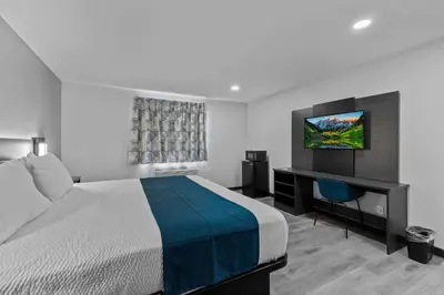 a bedroom with a bed and a desk and a television at Motel 6 Brighton CO Denver Northeast in Brighton