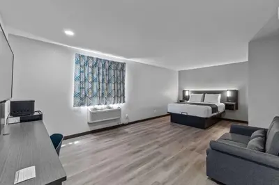 a living room with a bed and a couch at Motel 6 Brighton CO Denver Northeast in Brighton