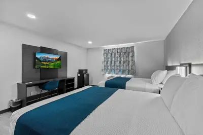 a hotel room with two beds and a desk at Motel 6 Brighton CO Denver Northeast in Brighton