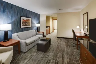 a living room with a couch and a desk at Drury Plaza Hotel Denver Westminster in Westminster