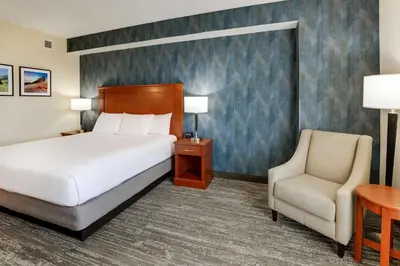 a hotel room with a bed and a chair at Drury Plaza Hotel Denver Westminster in Westminster