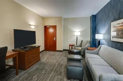 a hotel room with a couch and a flat screen tv at Drury Plaza Hotel Denver Westminster in Westminster