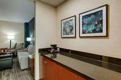 a hotel room with a reception desk and a living room at Drury Plaza Hotel Denver Westminster in Westminster