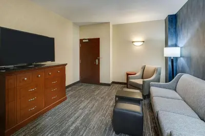 a hotel room with a couch and a flat screen tv at Drury Plaza Hotel Denver Westminster in Westminster