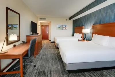 a hotel room with two beds and a desk at Drury Plaza Hotel Denver Westminster in Westminster