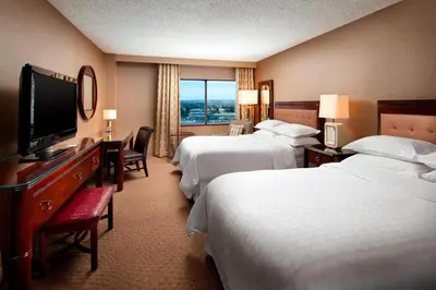 a hotel room with two beds and a flat screen tv at Sheraton Hotel Denver Tech Center in Greenwood Village