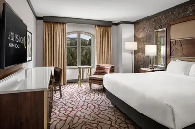 a hotel room with a bed and a desk and a television at Horseshoe Black Hawk, A Caesars Destination in Black Hawk
