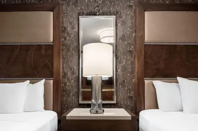 a hotel room with two beds and a mirror at Horseshoe Black Hawk, A Caesars Destination in Black Hawk
