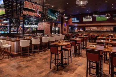 a restaurant with tables and chairs and a bar at Horseshoe Black Hawk, A Caesars Destination in Black Hawk