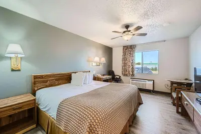 a hotel room with a bed and a television at Travelodge by Wyndham Longmont in Longmont