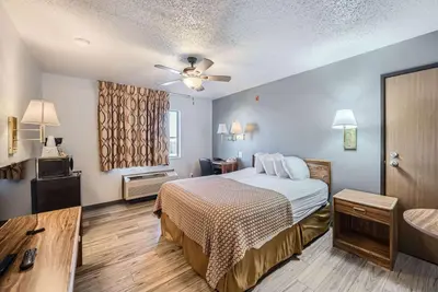 a hotel room with a bed and a television at Travelodge by Wyndham Longmont in Longmont