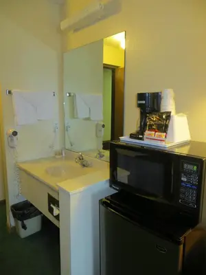 a bathroom with a microwave and a sink at Travelodge by Wyndham Longmont in Longmont