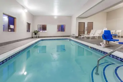 a pool with blue water in a hotel room at Travelodge by Wyndham Longmont in Longmont