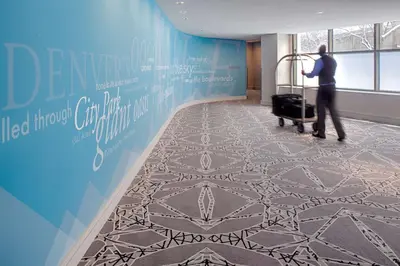 a man pushing a luggage cart in an airport hallway at Hyatt Regency Denver Tech Center in Denver
