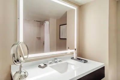a bathroom with a white sink and a large mirror at Grand Hyatt Denver in Denver