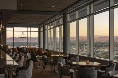 a restaurant with tables and chairs and large windows at Hyatt Regency Denver at Colorado Convention Center in Denver