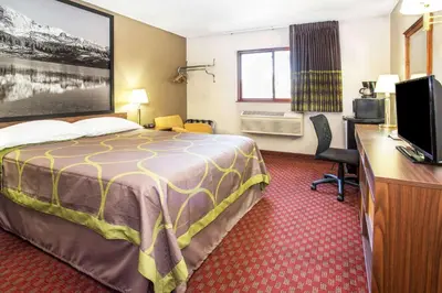 a hotel room with a bed and a desk at Super 8 by Wyndham Longmont/Del Camino in Longmont
