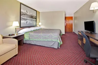 a hotel room with a bed and a flat screen tv at Super 8 by Wyndham Longmont/Del Camino in Longmont